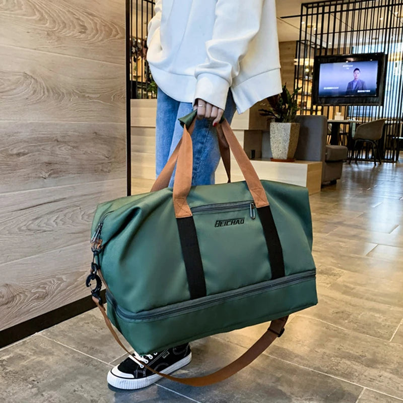 Person holding a green duffel bag with brown straps in a modern indoor setting.