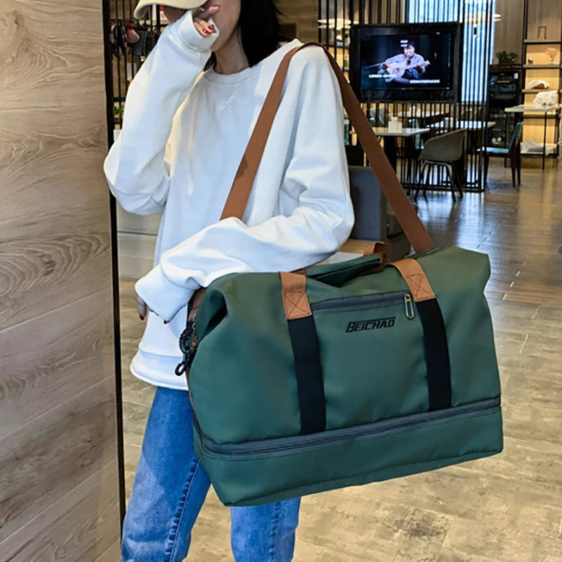 Person holding a green duffel bag with brown straps in an indoor setting.