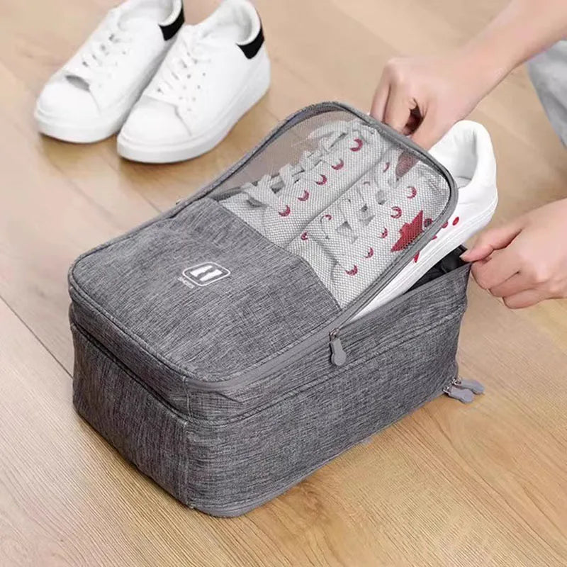 Person placing a white sneaker into a gray shoe organizer on a wooden floor.