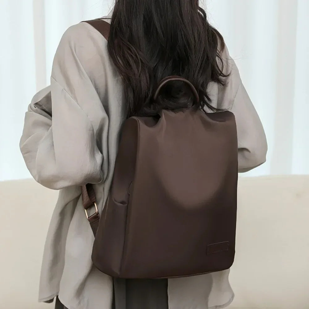 Person wearing a brown backpack in a neutral setting